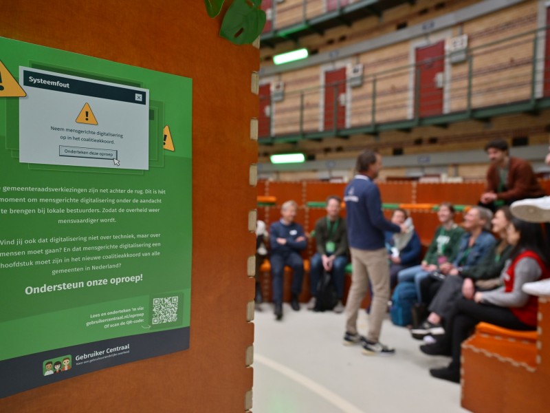 De mensenbieb met op de voorgrond een foto van poster oproep digitale toegankelijkheid opnemen in coalitieakkoord